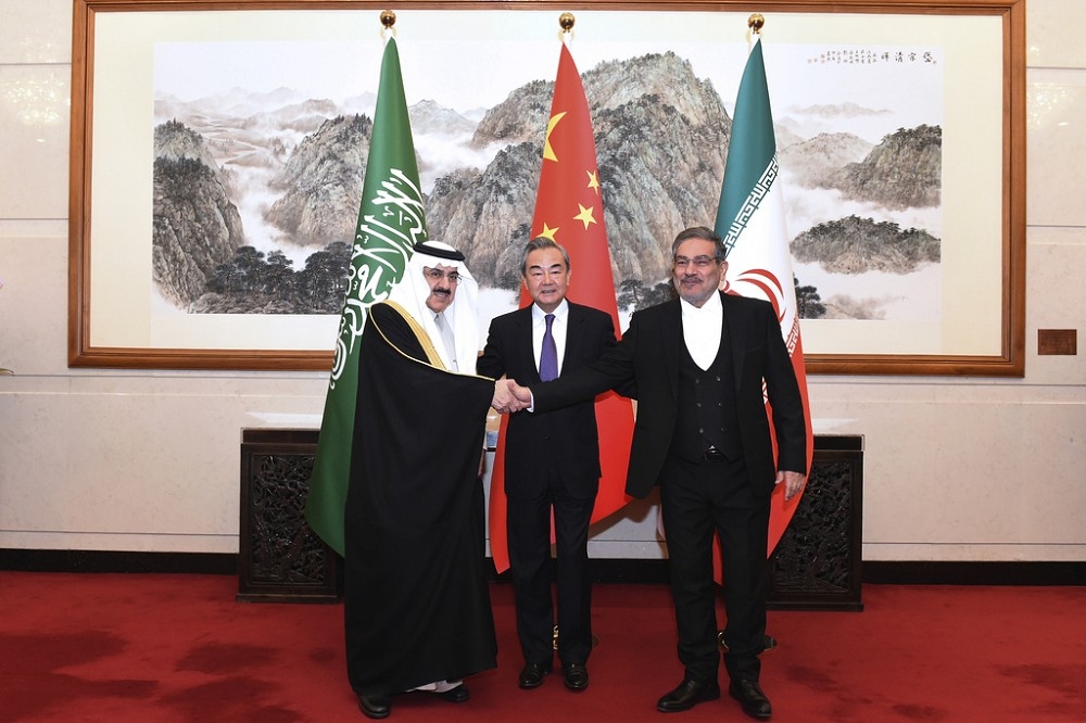 沙伊兩國外長由中國外交最高層級的官員王毅居中，牽手展現和解之意。（美聯社）