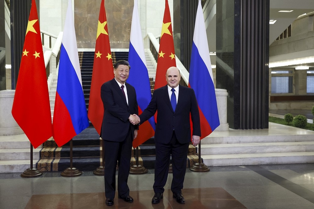 習近平（左）與米舒斯京會面時，表示已邀請普丁在年內訪問中國。（美聯社）