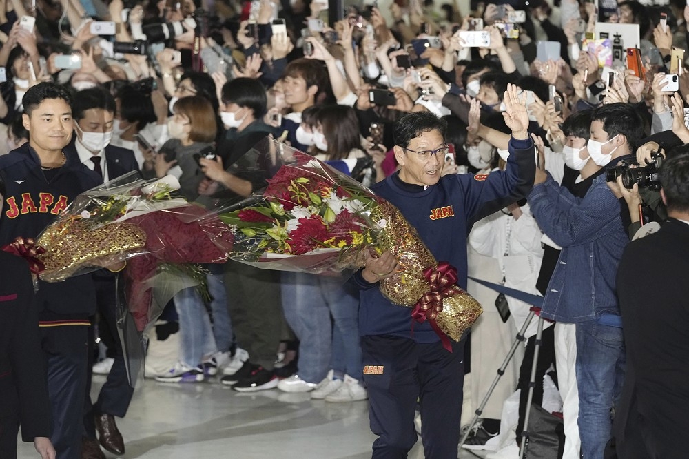 日本隊23日返國，受到民眾熱烈歡迎，總教練栗山英樹與球員們接受航空公司獻上花束，並向群眾揮手致意。（美聯社）