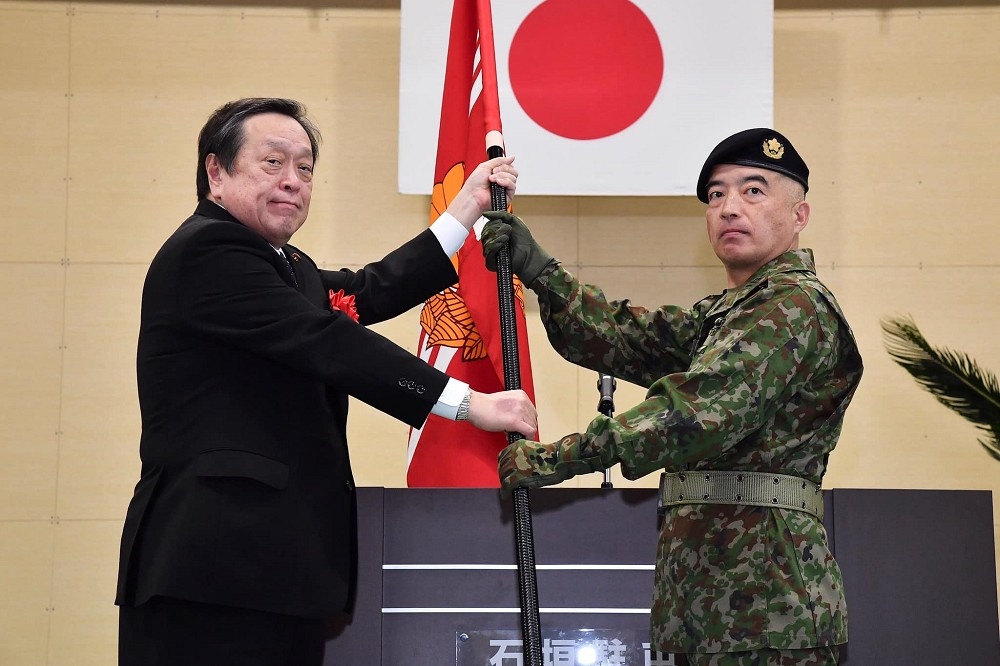 石垣駐屯地指揮官井上雄一朗上校（右）接過日本防衛大臣濱田靖一手中的隊旗。（取自日本防衛省臉書）