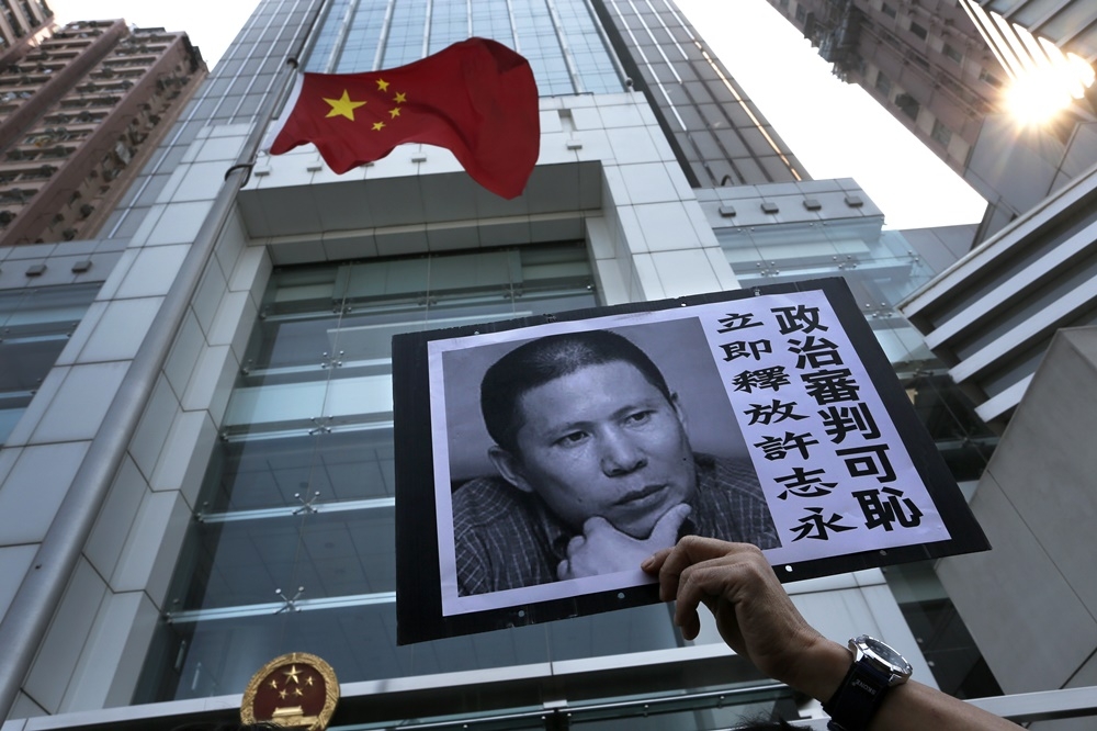 中國著名維權人士許志永遭重判14年。圖為2014年香港民運入士在中聯辦外聲援許志永。（美聯社）