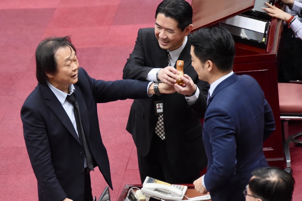 台北市議員王世堅在質詢蔣萬安時，送上棕熊造型的「螺絲起子」，強調「做好市政的第一步就是拴緊螺絲，拴緊市府團隊的螺絲」。（張哲偉攝）