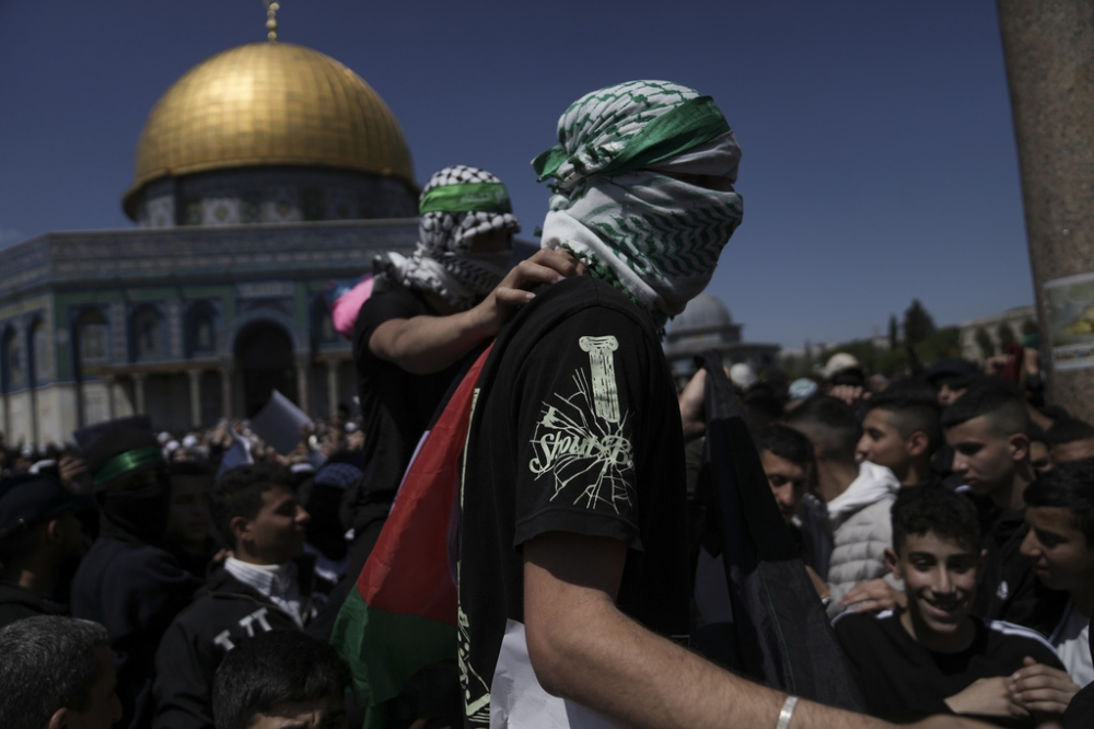 蒙面的巴勒斯坦人在耶路撒冷老城的阿克薩清真寺，表達支持哈馬斯。（美聯社）