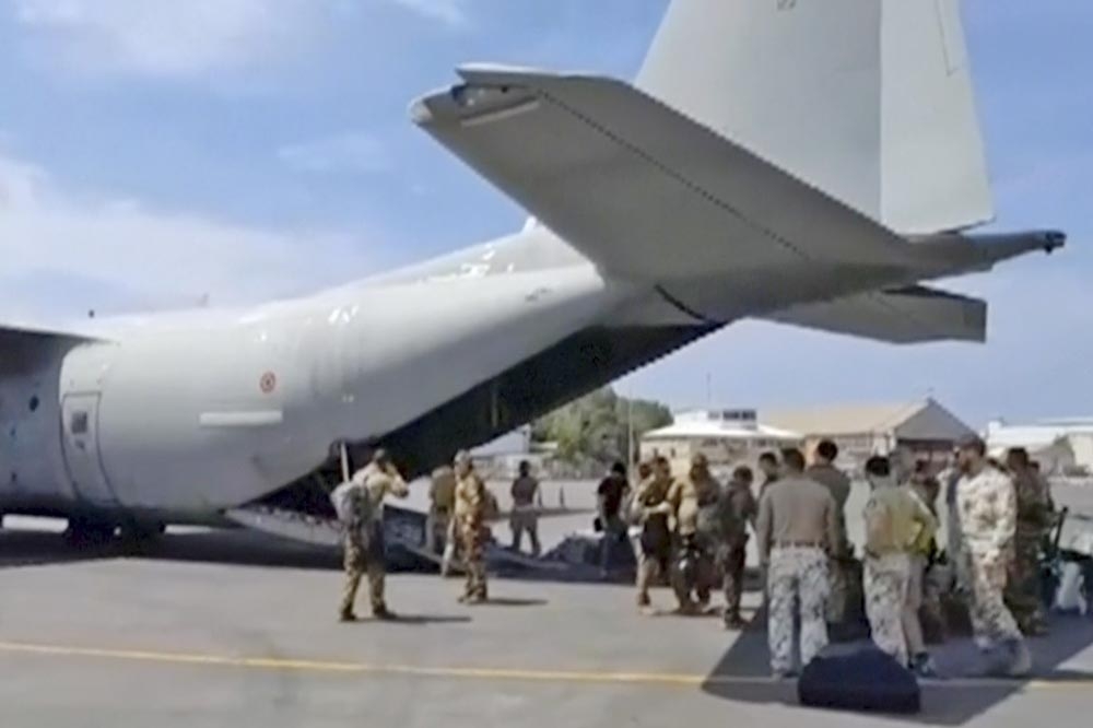 義大利軍方人員23日在喀土木機場安排撤離事宜。（美聯社）