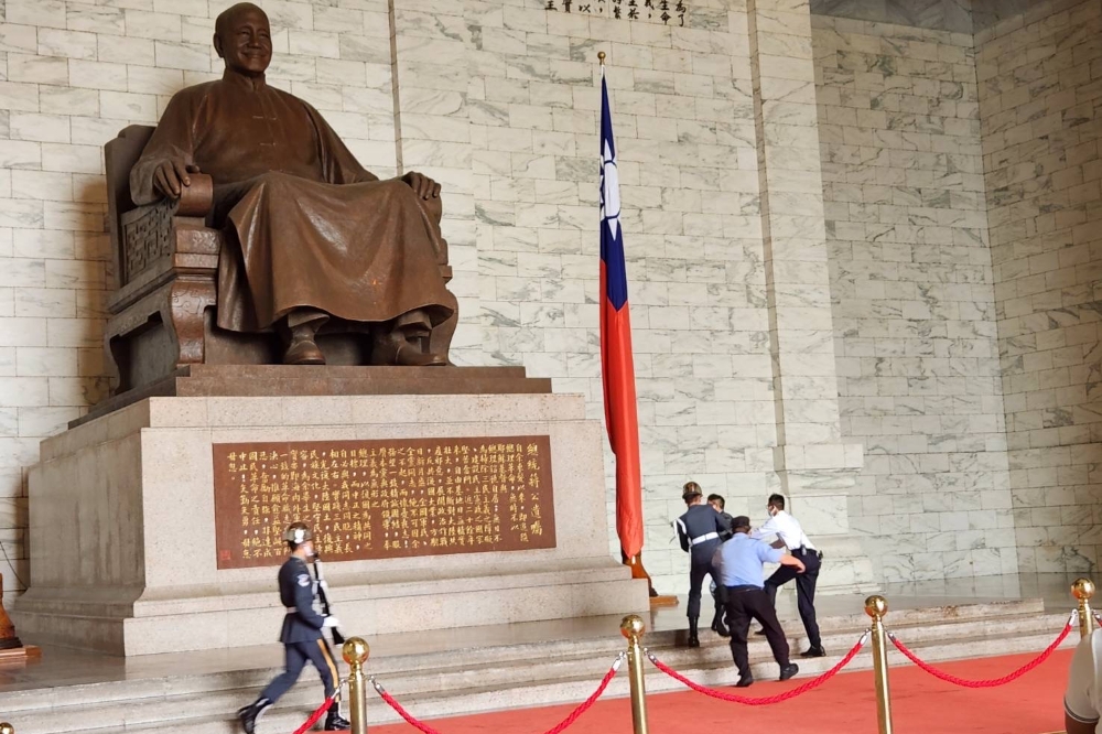 獨派團體「台灣國」成員今天（27日）前往中正紀念堂試圖以漆彈攻擊蔣介石銅像，隨即遭到憲兵及便衣警察壓制。（翻攝畫面）