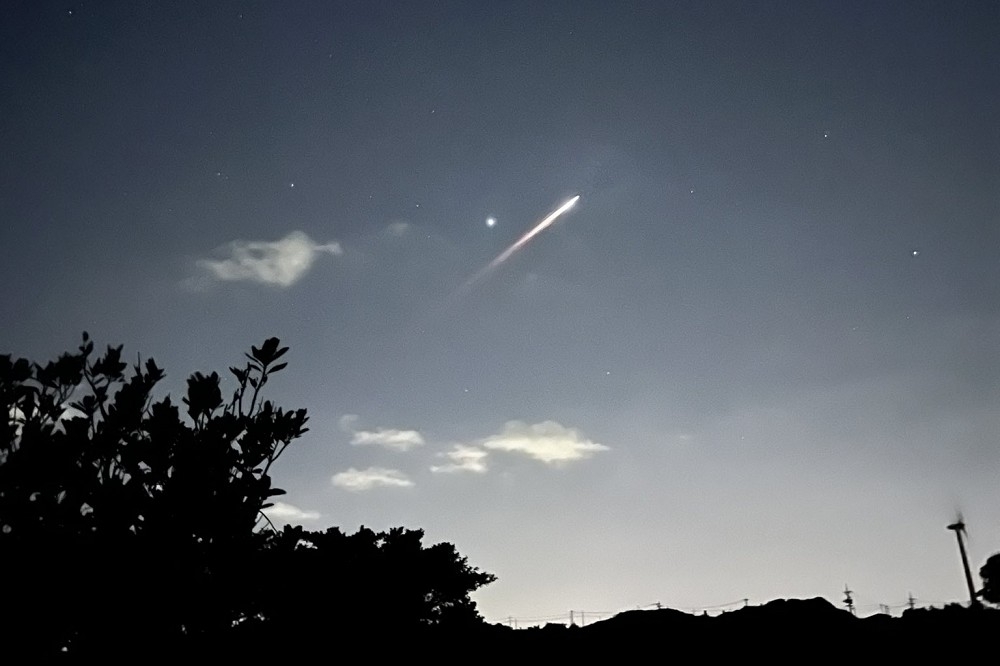 日本沖繩10日晚間8時30分許，民眾相繼發現天空出現有明亮軌跡的不明物體。（截自推特）