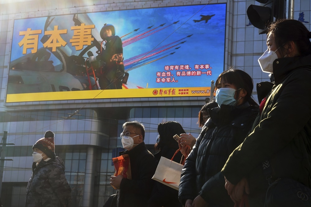 專家認為，中國蠶食台灣政軍和經濟空間比武統的威脅更大。圖為北京街頭宣傳解放軍的影片。（美聯社）