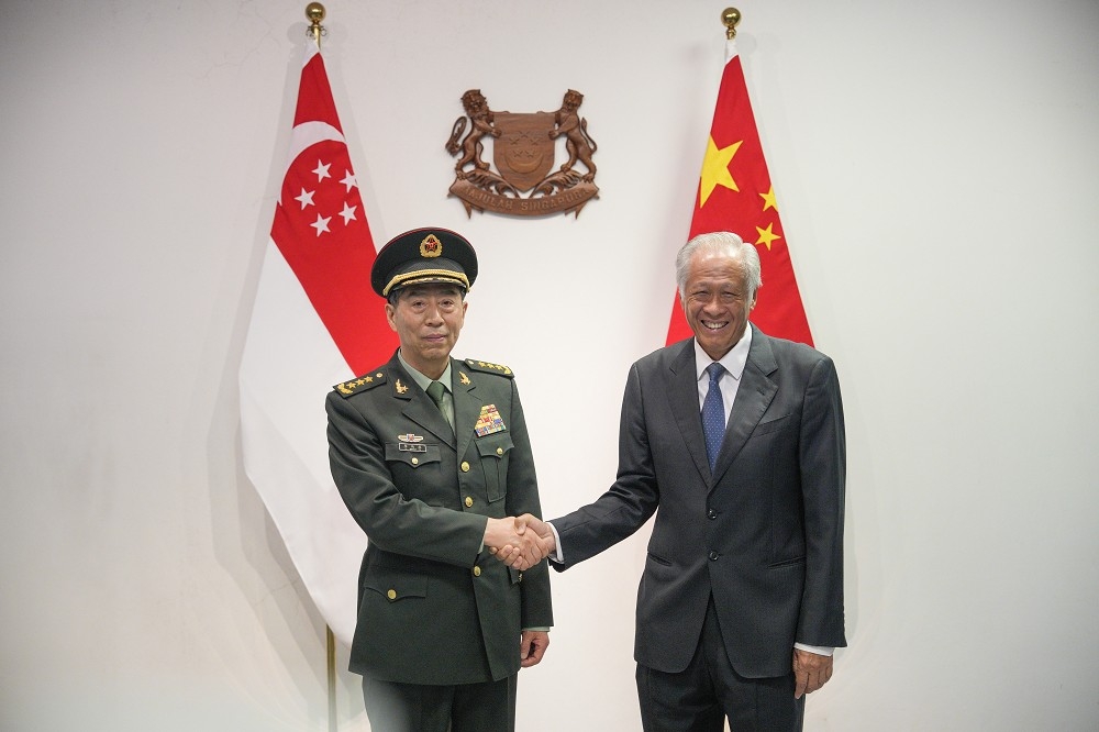 中國防長李尚福（左）與新加坡防長黃永宏（右）會晤，雙方簽署備忘錄，將設立兩國軍事熱線。（美聯社）