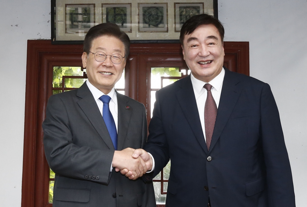 中國駐韓國大使邢海明（右）與韓國主要反對黨民主黨領袖李在明在韓國首爾中國大使官邸共進晚餐前握手，這場聚會卻引發中韓雙方互嗆。（美聯社）