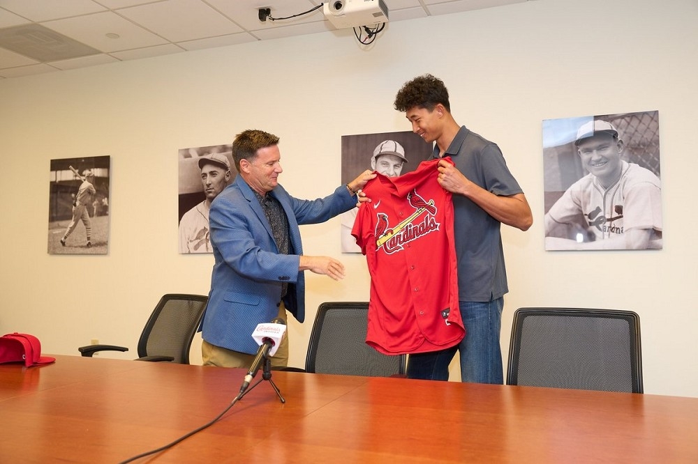 林振瑋從球隊高層接過紅雀球衣，象徵正式加盟MLB。（取自聖路易紅雀隊）
