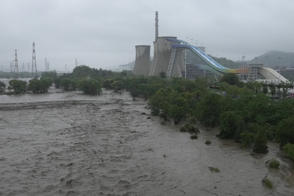 北京接連大雨導致山洪暴發，永定河洩洪導致兩岸氾濫，橋梁崩塌導致至少5車落水。（美聯社）