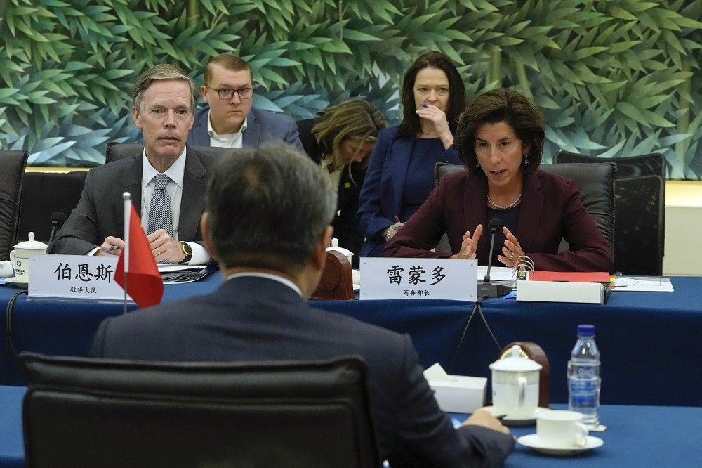 美國商務部長雷蒙多（右）今起展開與中國官員對話的行程，左為美國駐中國大使伯恩斯。（美聯社）