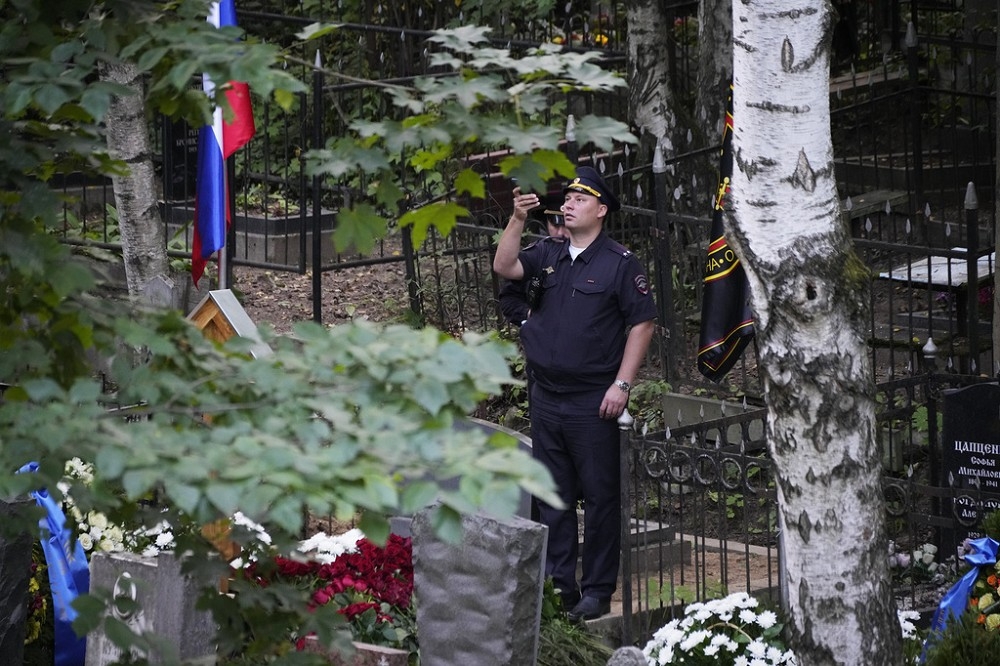 一個負責確保葬禮安全的俄國警察中校，也用手機拍攝普里戈辛的墓碑。（美聯社）