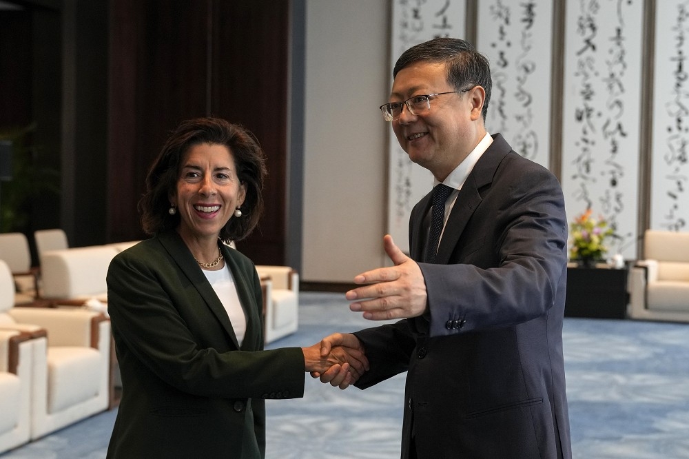 美國商務部長雷蒙多（左）30日與上海市委書記陳吉寧（右）會晤，呼籲建立更可預測的經商環境。（美聯社）