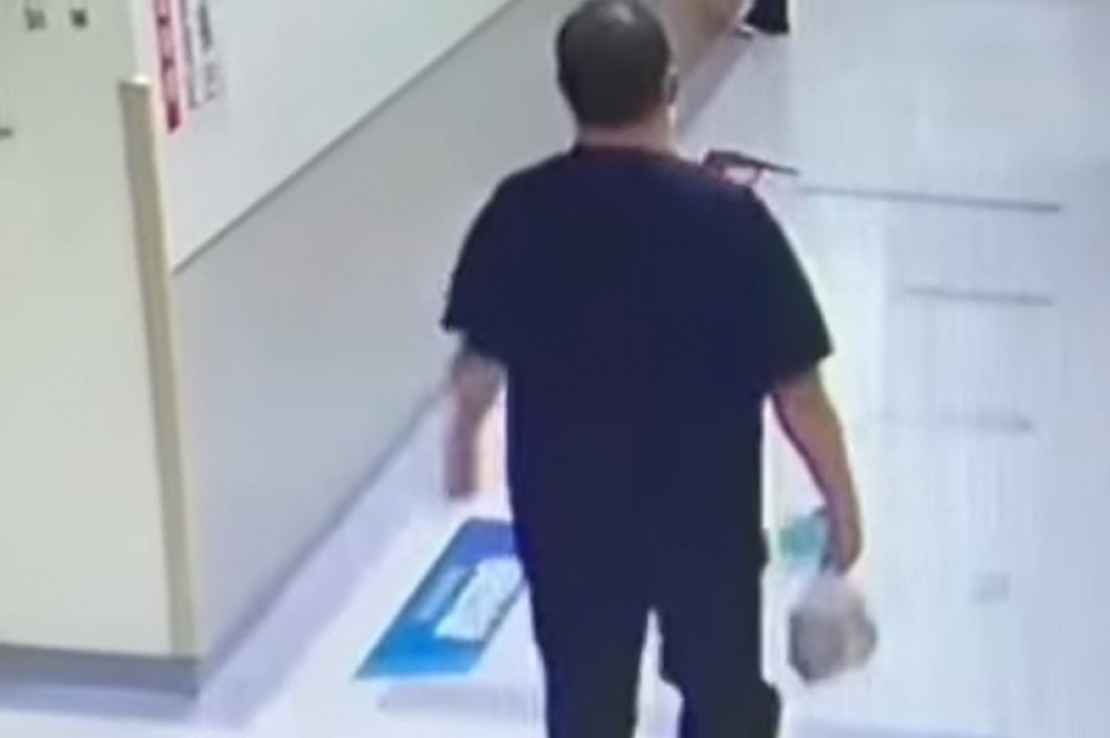 高姓男子被拍到拿著塑膠袋，裡面疑包著手槍與子彈，進入大同醫院1樓廁所。（翻攝畫面）