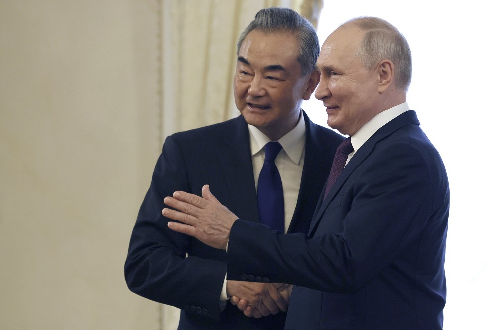 普丁（右）與王毅在聖彼得堡會面，並接受邀請於10月出訪北京。（美聯社）