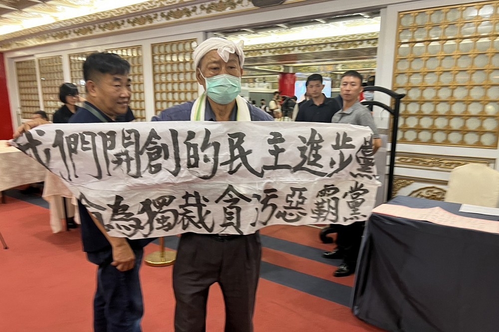 民進黨創黨人之一的魏耀乾，今天在37周年活動上，高舉「我們開創的民進黨，已淪為獨裁貪污惡霸黨」布條抗議。（讀者提供）