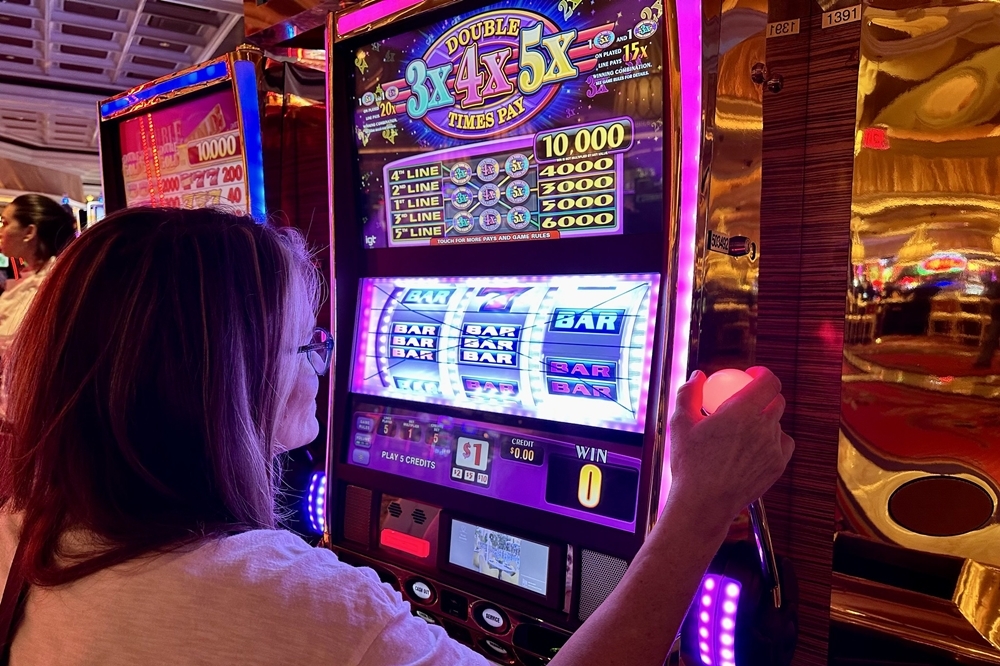 賭博示意圖，與內文無關。（2022 © Jonathan Cutrer , Woman playing a slot machine in Las Vegas @ Flickr, CC BY-SA 2.0.）