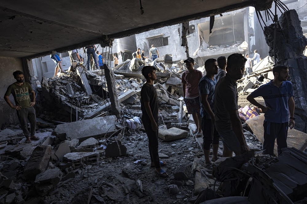 以色列發動空襲後，巴勒斯坦民眾在瓦礫堆中尋找生還者。（美聯社）