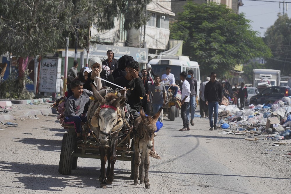 加薩北部地帶的巴勒斯坦民眾，在以色列的撤離通告下，攜家帶眷逃離家園。（美聯社）
