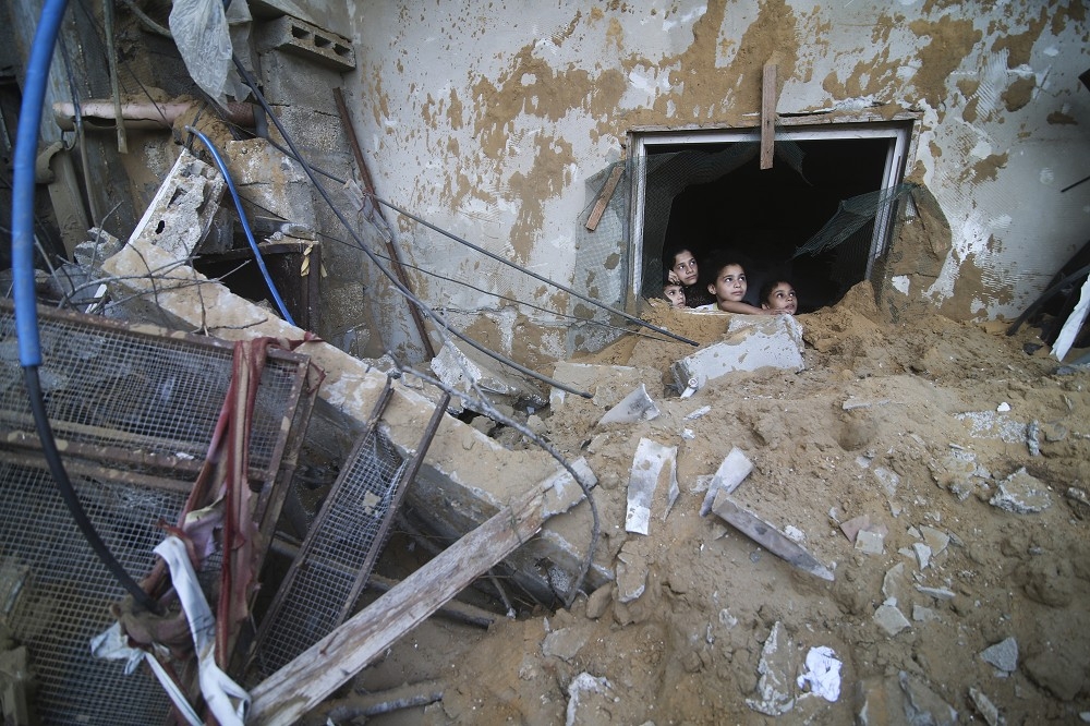 拜登受訪時呼籲以色列克制。圖為14日以軍空襲後的加薩南部城市拉法。（美聯社）
