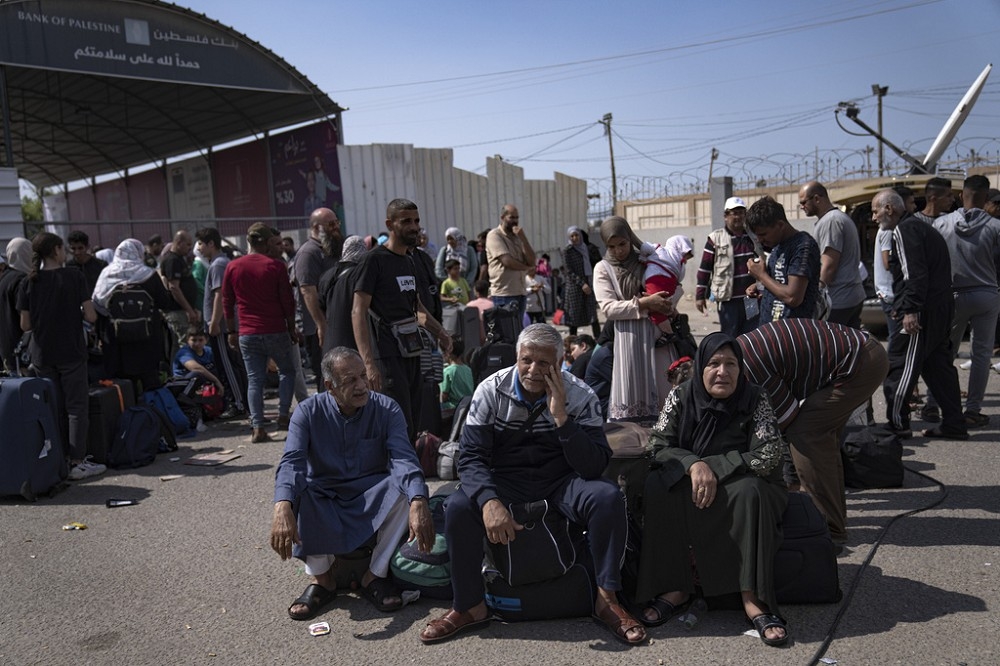埃及表明以色列未同意開放拉法過境點，因此當地急需的民生物資無法運入加薩。圖為在過境點外等待過境的巴勒斯坦難民。（美聯社）