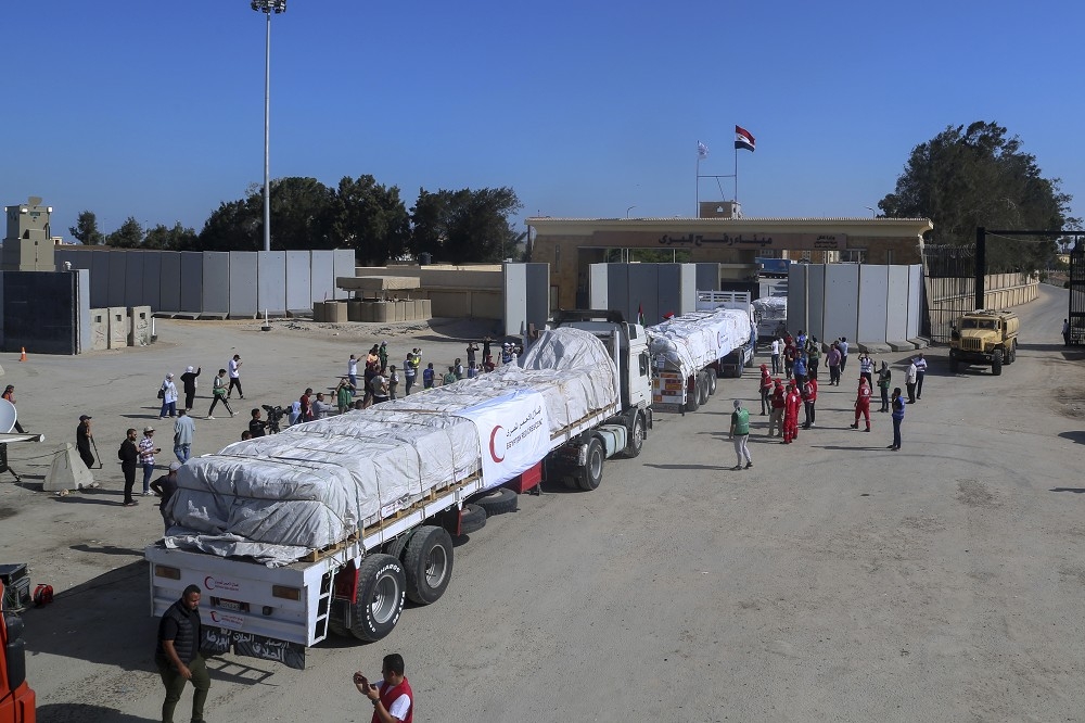 載運包括聯合國以及國際救援組織所提供物資的車隊，21日通過埃及與加薩邊界的關卡拉法。（美聯社）