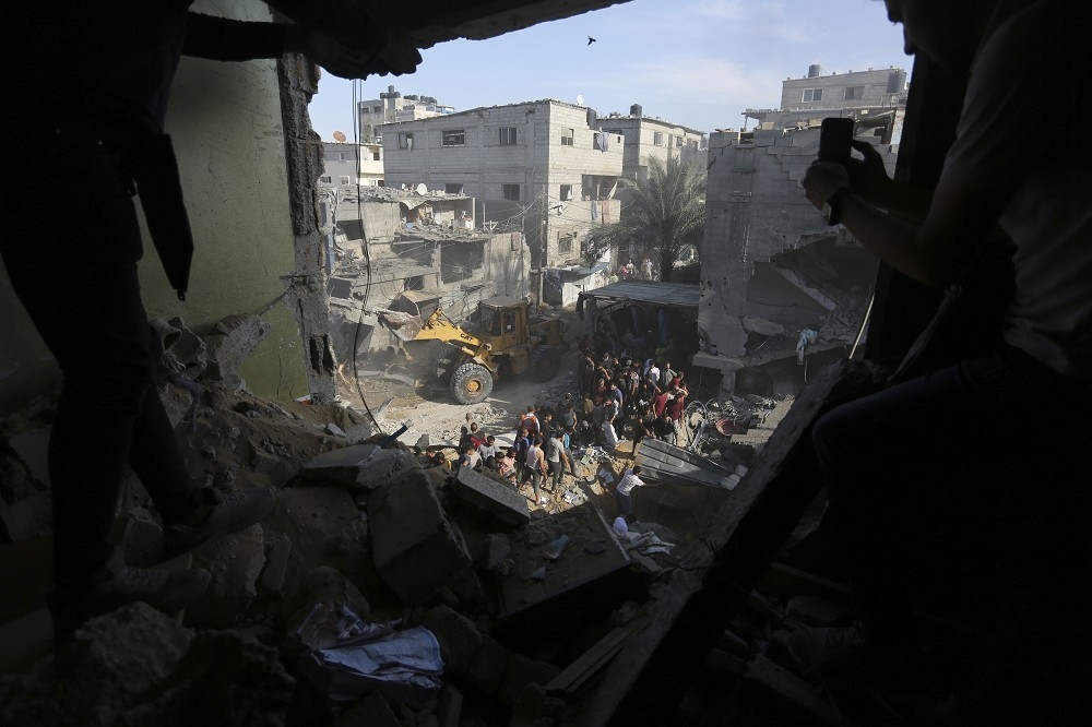 加薩民眾30日在以色列空襲後的拉法尋找生還者。以色列目前無意停止反擊攻勢。（美聯社）
