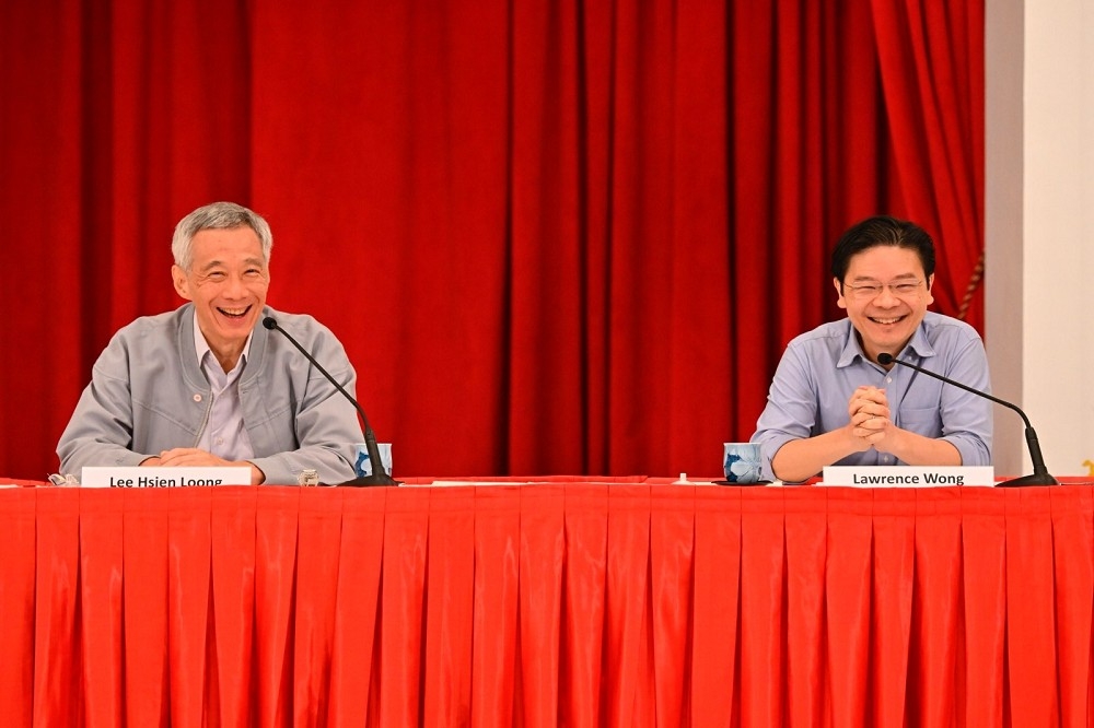 新加坡總理李顯龍（左）宣布，明年交棒第四代接班人黃循財（右），領導人民行動黨。（美聯社）