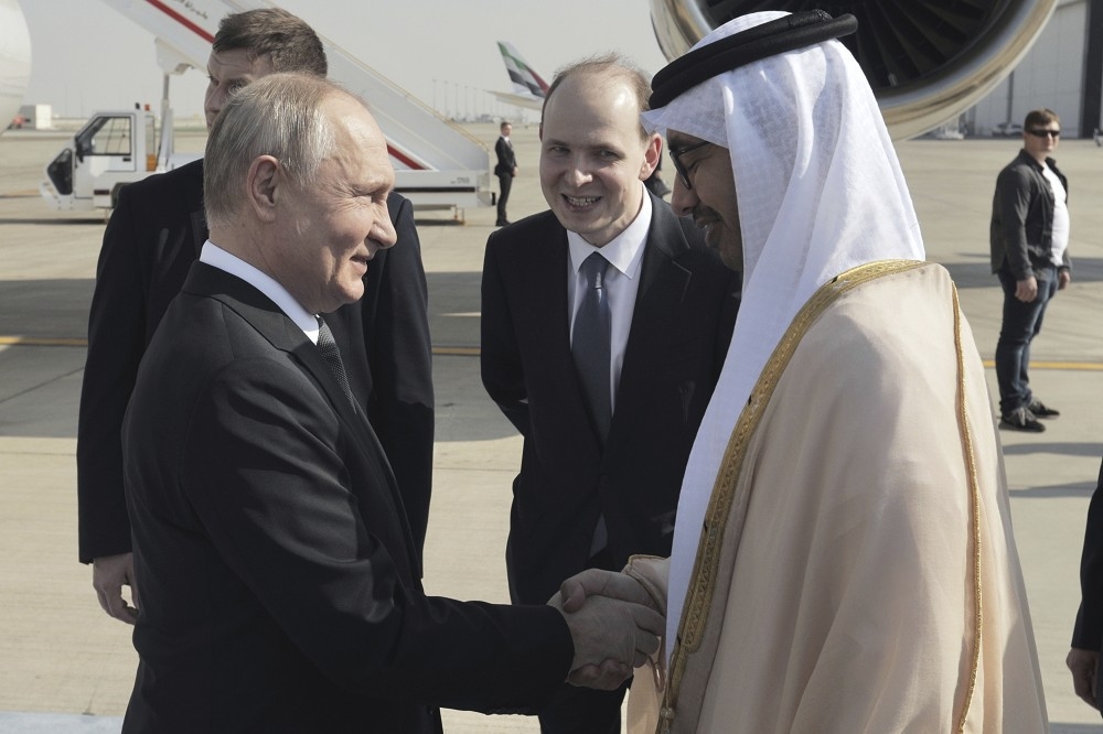 普丁（左）飛抵杜拜，接受阿聯外長的熱烈歡迎。（美聯社）