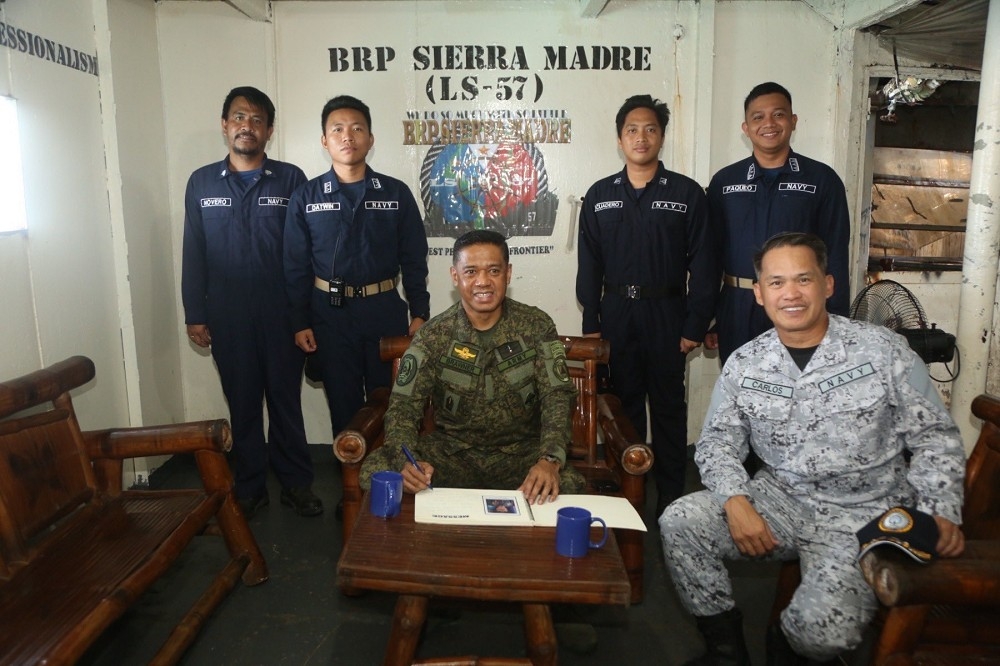 菲軍參謀長布勞納上將與西部指揮部司令卡洛斯中將，以「馬德雷山脈號」艦徽為背景和官兵合影。（取自AFP）