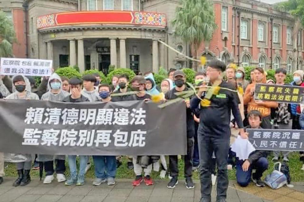 黃國昌28日到監察院抗議包庇賴清德老家違建，卻遭台灣基進成員拿太陽花砸臉。（取自王浩宇臉書）