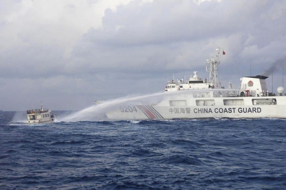 中國海警船在南海爭議海域，以水砲對菲國海軍運補船進行攻擊。（美聯社）