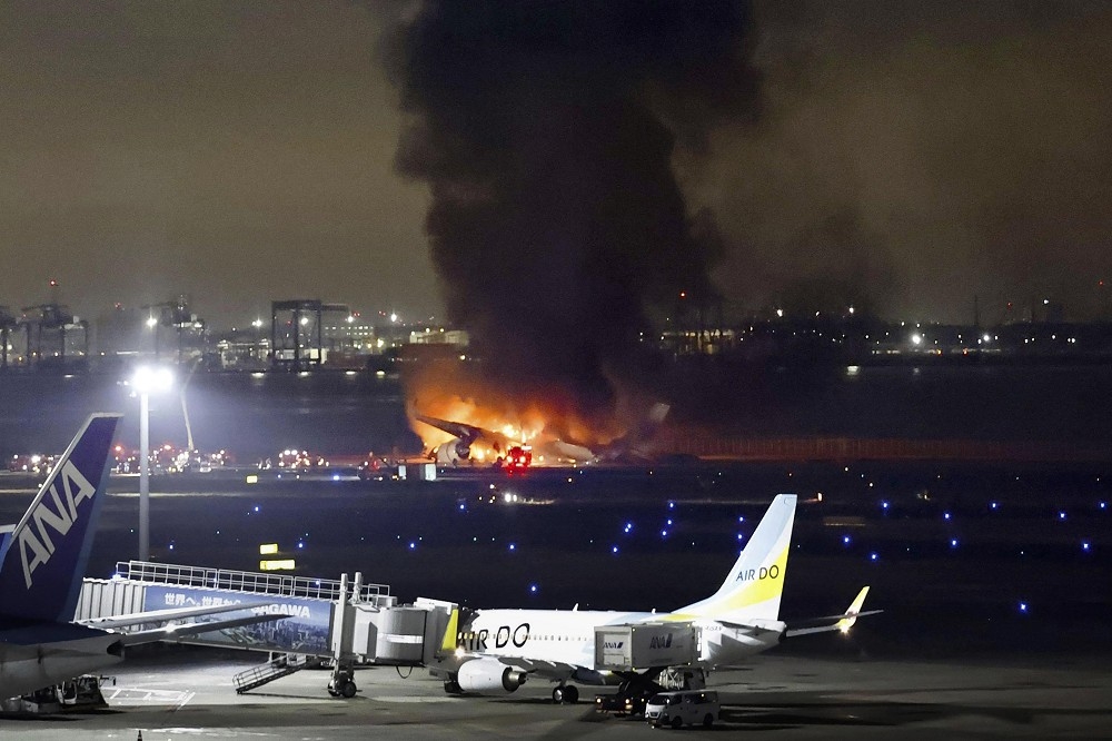 日本羽田機場日航班機與海上保安廳飛機發生撞擊後起火燃燒。（美聯社）