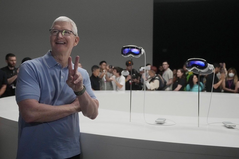 苹果执行长库克去年6月在总部与Apple Vision Pro合照。瑞银认为该产品今年无助苹果收益。（美联社）(photo:UpMedia)