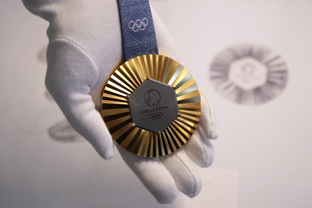 今年巴黎奧運的獎牌設計，鑲嵌在獎牌上的鐵片為原艾菲爾鐵塔的部件。（美聯社）