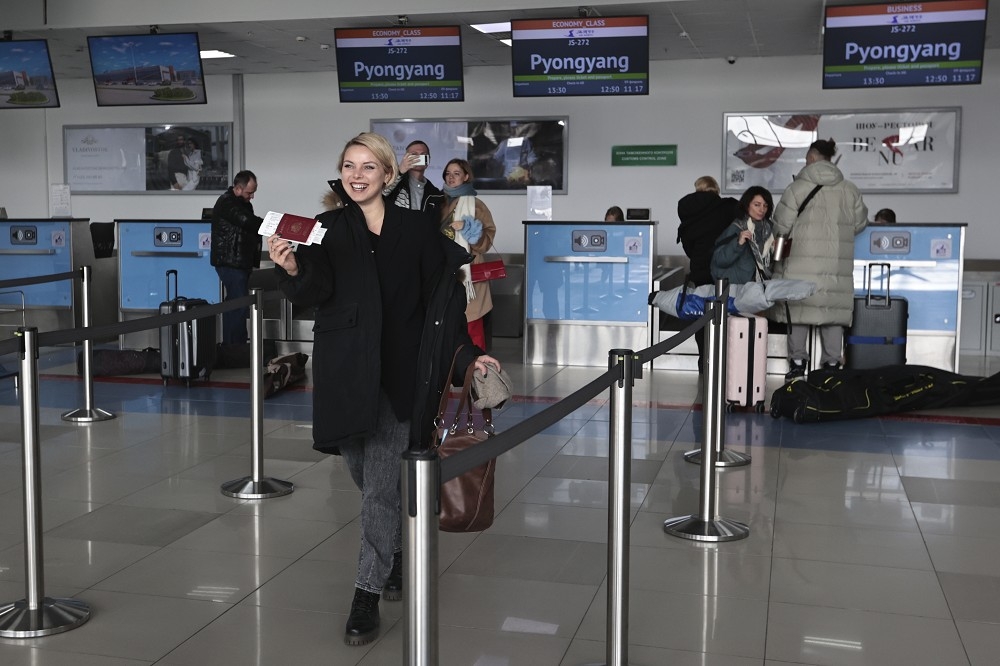准备前往北韩旅游的俄国民众，在海参崴机场开心秀出手中的护照与机票。（美联社）(photo:UpMedia)