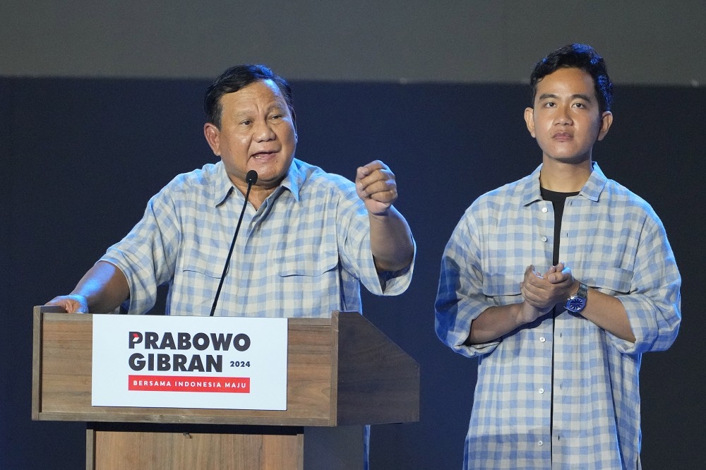 印尼总统候选人普拉伯沃（左）与搭档副手吉伯朗（右）宣布赢得总统大选，14日晚间在雅加达向民众谢票。（美联社）(photo:UpMedia)