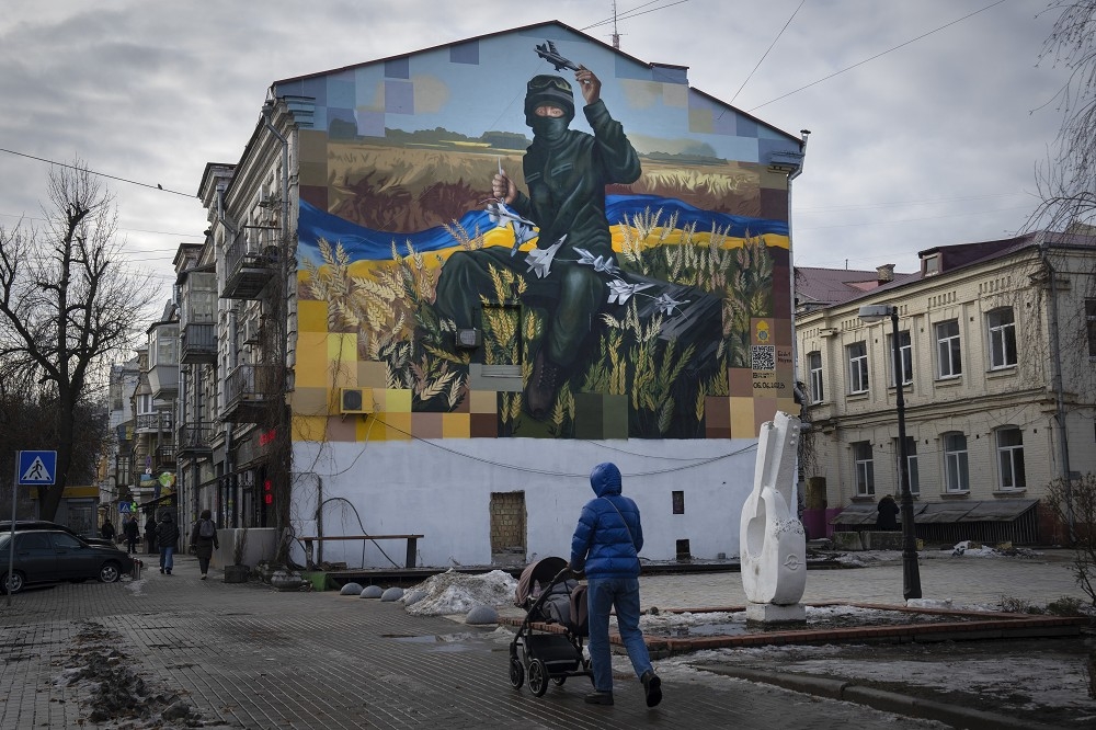 俄烏戰爭邁向第3個年頭，勉力支撐的烏克蘭所獲得的援助正不斷縮水，戰爭前景恐難樂觀，圖為基輔一處建築外牆上，烏軍英雄人物的彩繪。（美聯社）