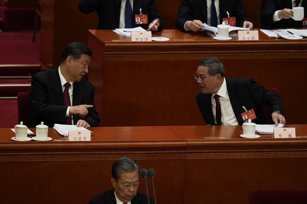 李強（右）的鋒頭料將遠遜於過去的中國總理。圖為5日兩會開幕式上，習近平與李強交談。（美聯社）