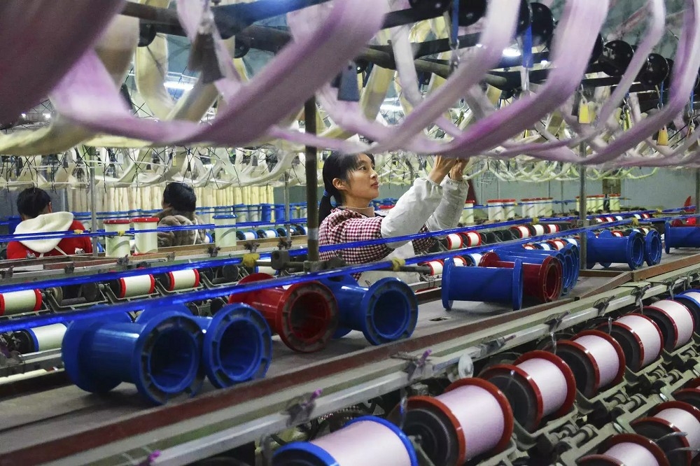 中國製造業利用中轉地規避關稅，獲得持續成長，但有可能因此招致各國反制手段。圖為安徽紡織品工廠運作情形。（美聯社）