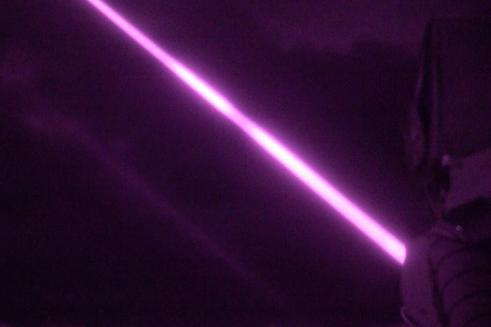 「龍火」雷射導能武器（LDEW）在赫布里底群島夜空發出紫色光束。（截自英國國防部影片）