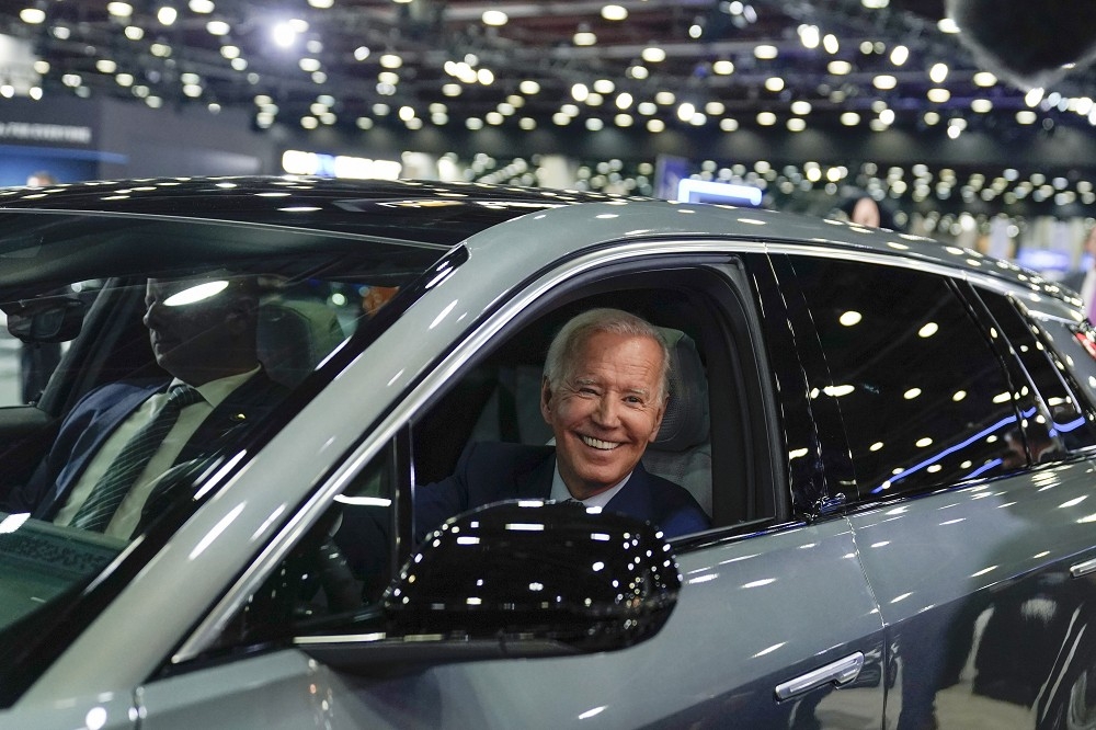 拜登政府頒布新的規範，將大幅提高電動車的銷售比率。圖為拜登2022年9月在底特律車展試乘凱迪拉克電動車。（美聯社）