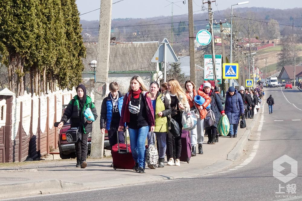 想要徒步前往波蘭的烏克蘭難民們行走在 M11 公路上