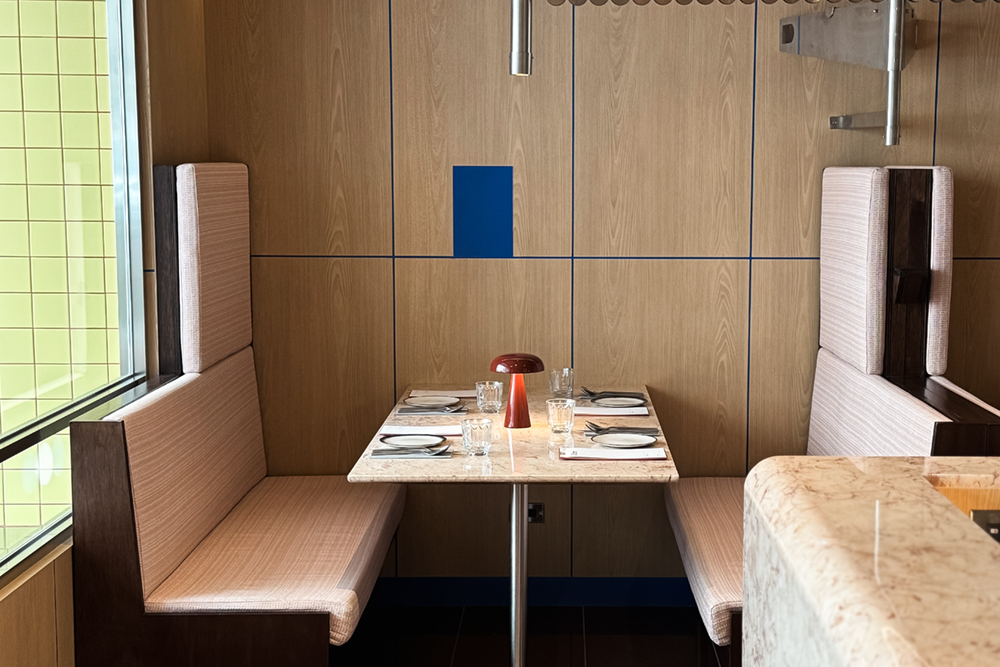 走進餐廳內，大量的木質飾面和特製沙發卡座設計，劃分出不同的用餐區域